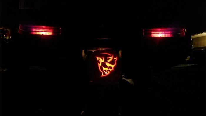 Dodge Demon pumpkin in front of the back end of a Dodge Demon