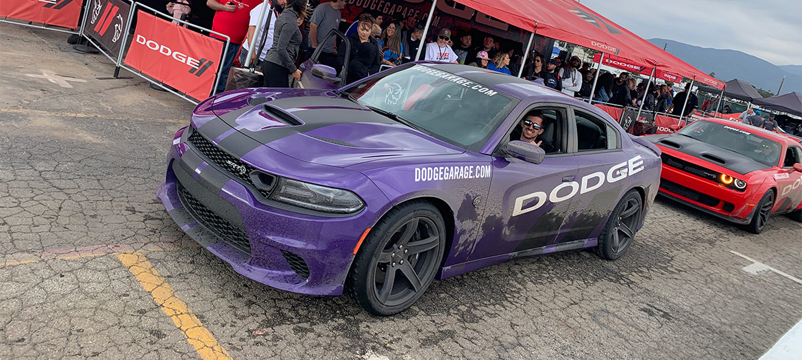 Line of Dodge thrill ride cars dropping off and picking up passengers