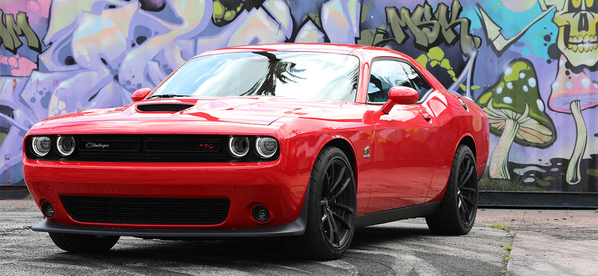 Red 1320 Challenger Drag Pak parked in front of graffiti filled walls