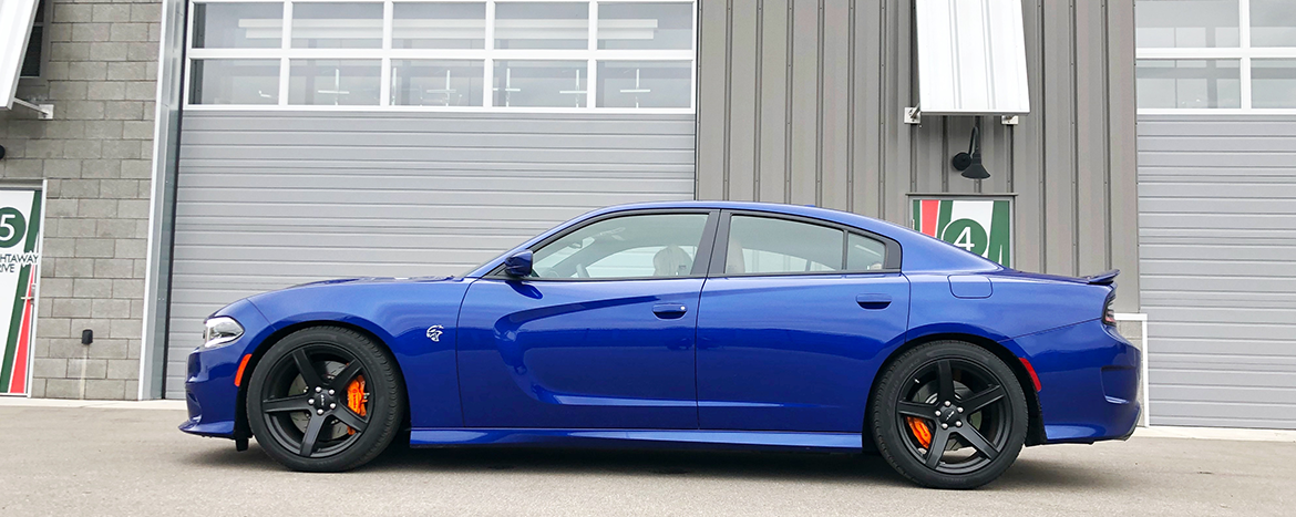 Bjue Charger Hellcat parked in front of a garage