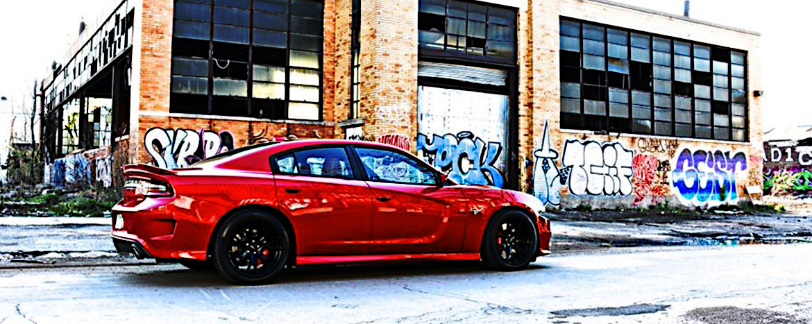 Red hellcat parked in front of abandoned building painted in graffiti
