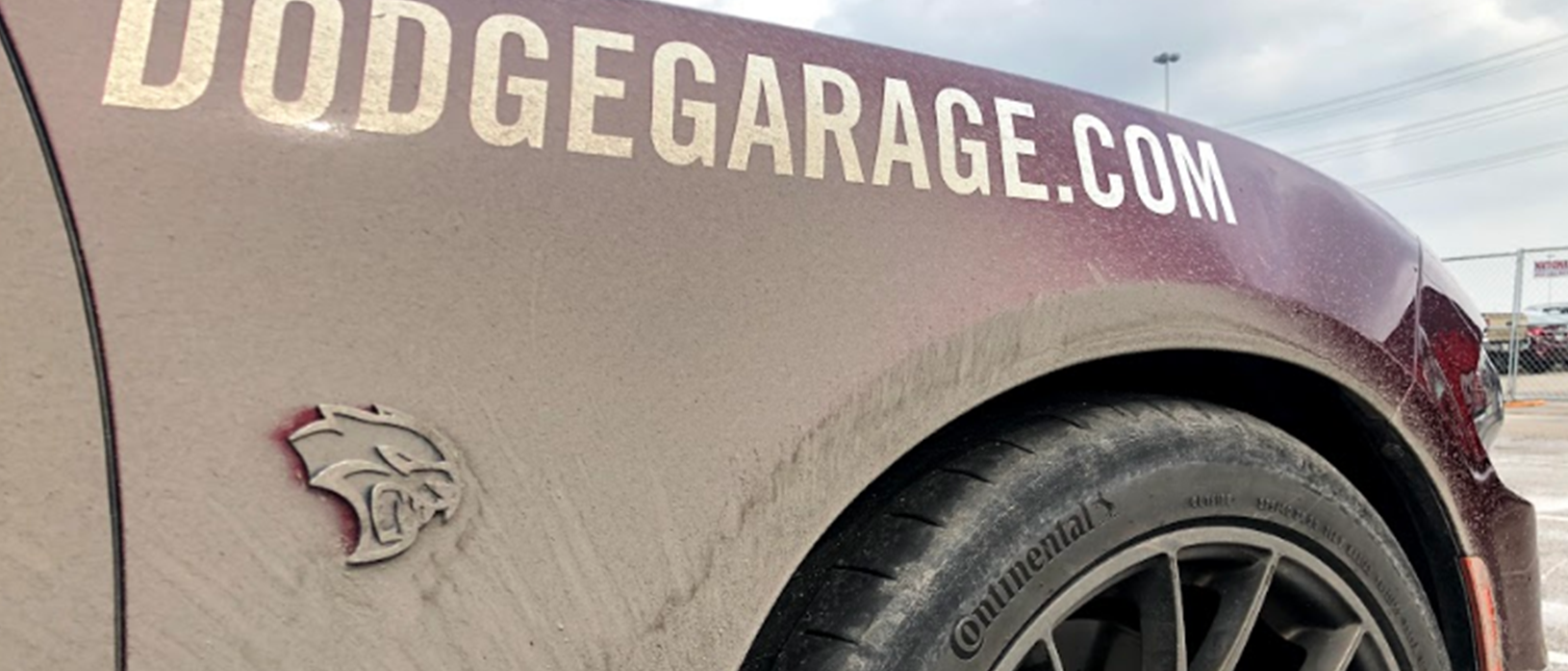 Front quarter panel of DodgeGarage.com thrill ride car with mud all over it