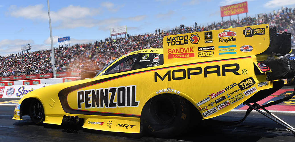 Matt Hagan preparing to race his Dodge Charger SRT Hellcat Funny car down the track with stands full of fans looking on