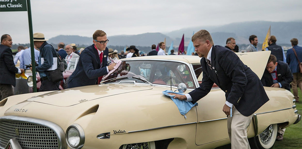 McPherson College students prepare a 1953 Hudson Italia Prototype Touring Coupe before they drive it onto the field at Pebble Beach.