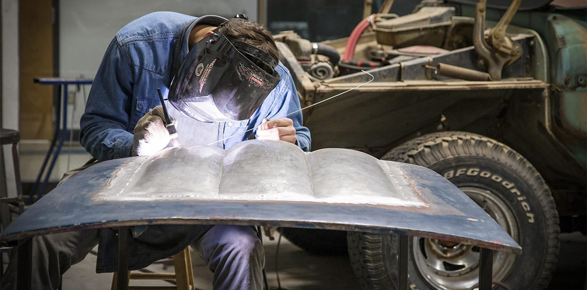A student works in the sheet metal lab on a custom built hood