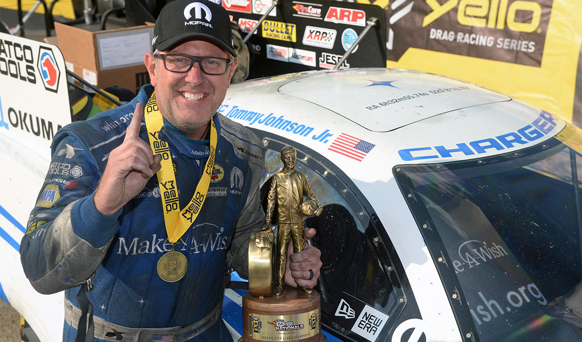 Tommy Johnson Jr. holding up his Wally trophy after winning NHRA Route 66