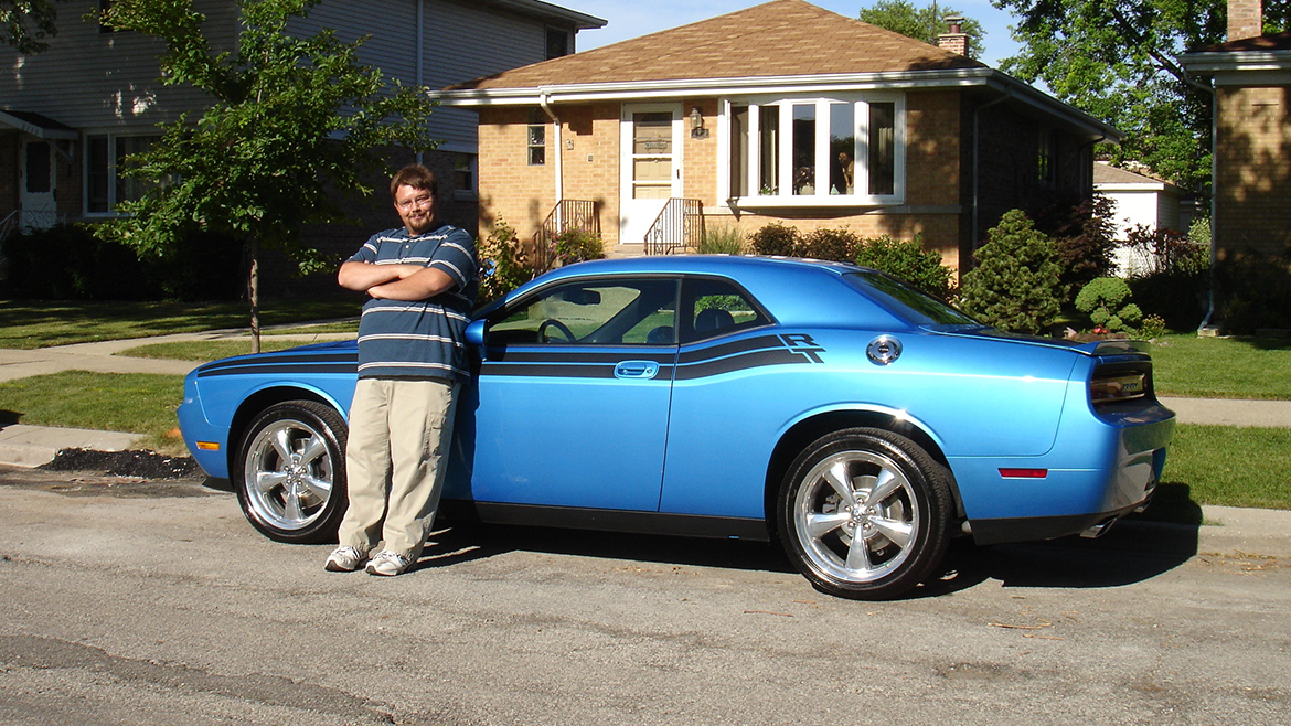 A man standing next to his 2009 Challenger R/T Classic in B5 Blue