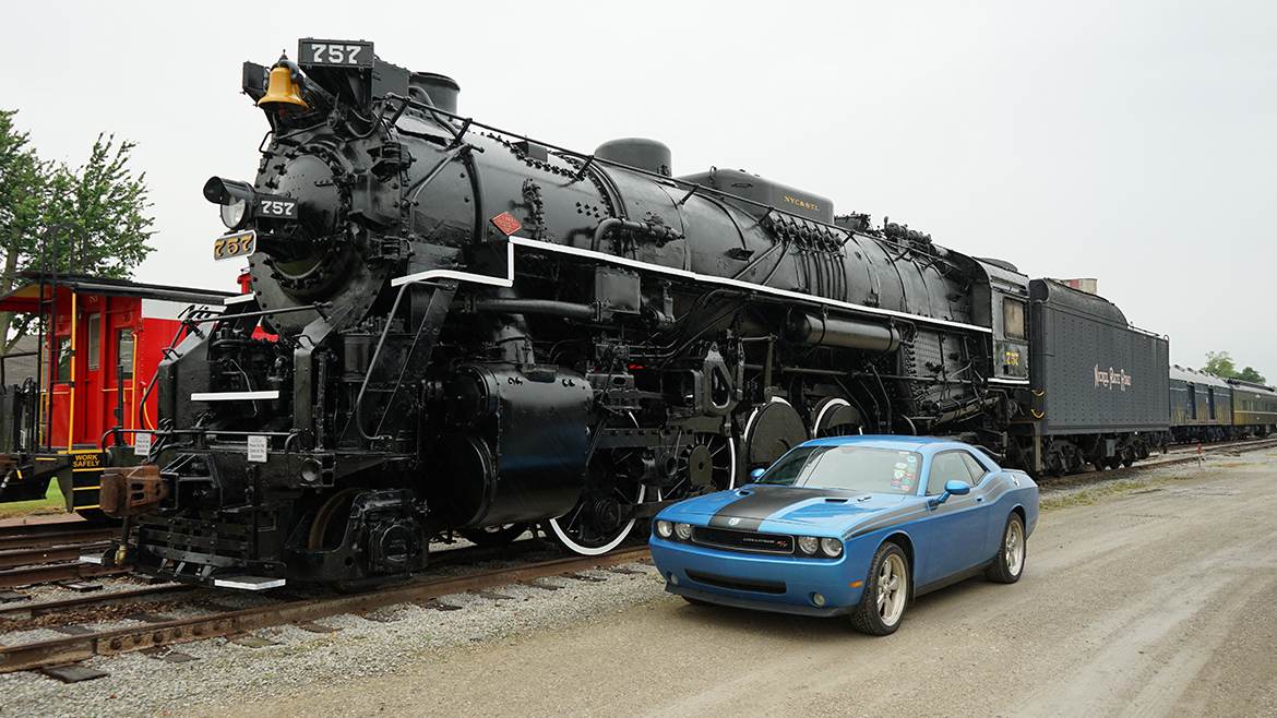 a 2009 Challenger R/T Classic in B5 Blue parked next to a black train on the railroad tracks