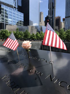 two flags and a rose on the edge of the nine eleven memorial