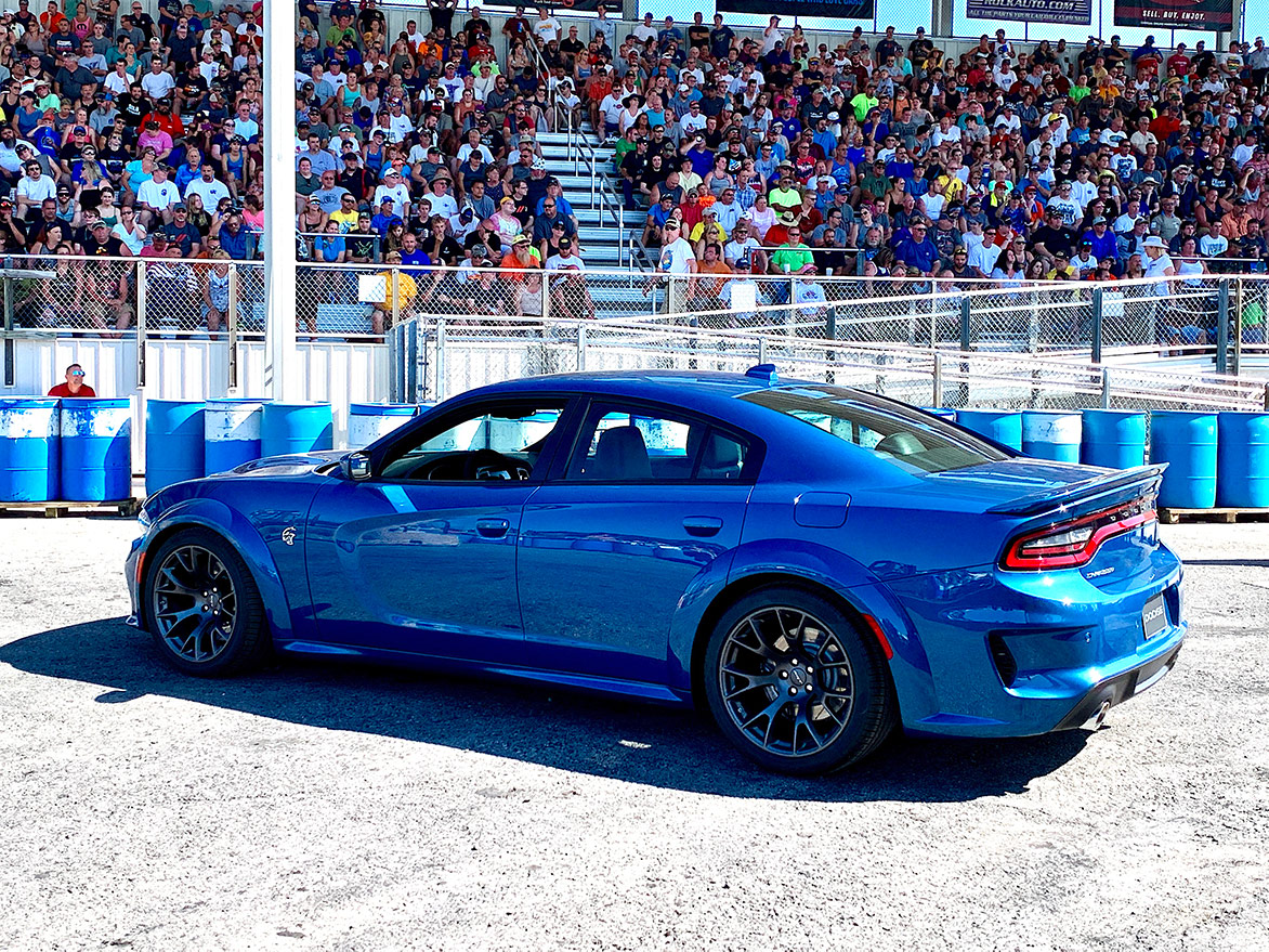 crowd sitting in bleachers watching a 2020 Charger Hellcat Widebody