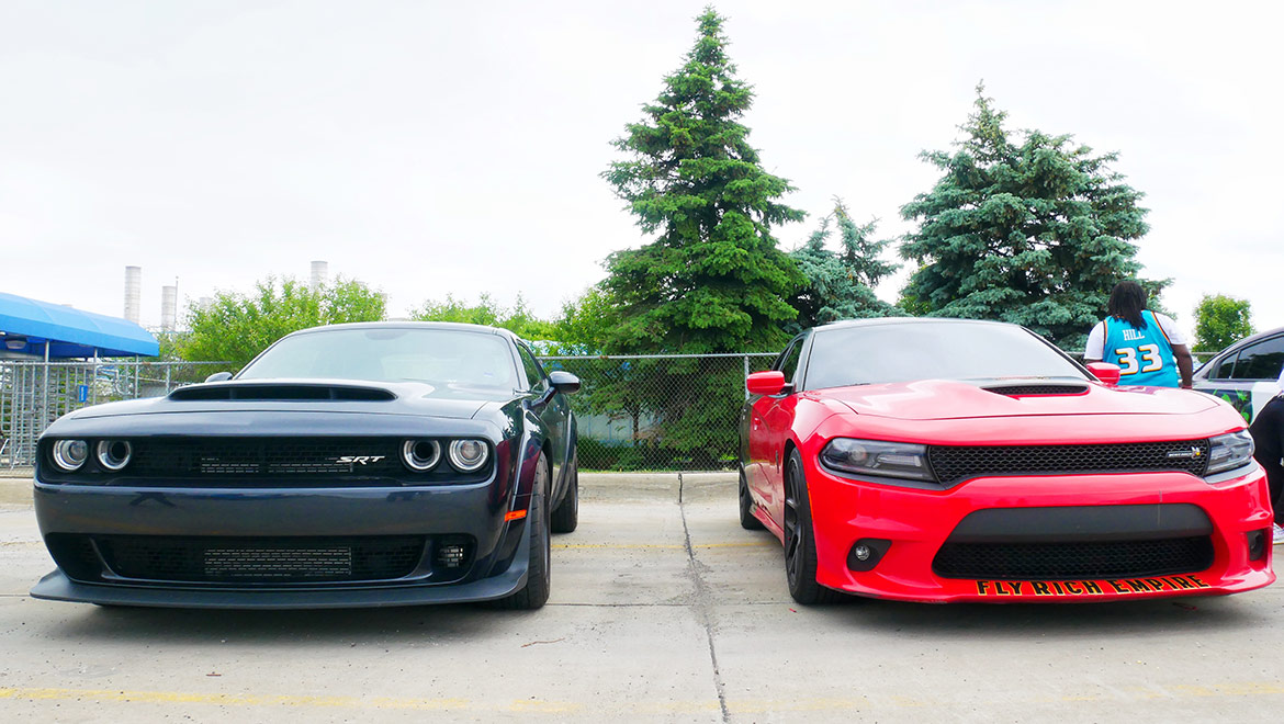 one red car and one black car parked next to eachother