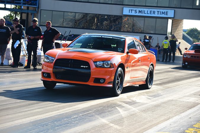 dodge vehicle on two wheels at the starting line of a drag strip