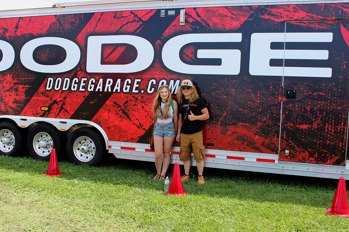 man and woman standing in front of a dodge trailer