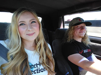 one woman and one man in the front seats of a car