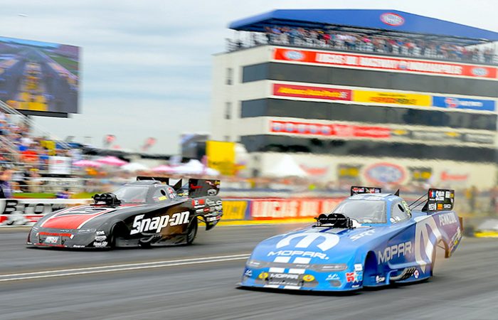 funny cars on the starting line of a drag strip