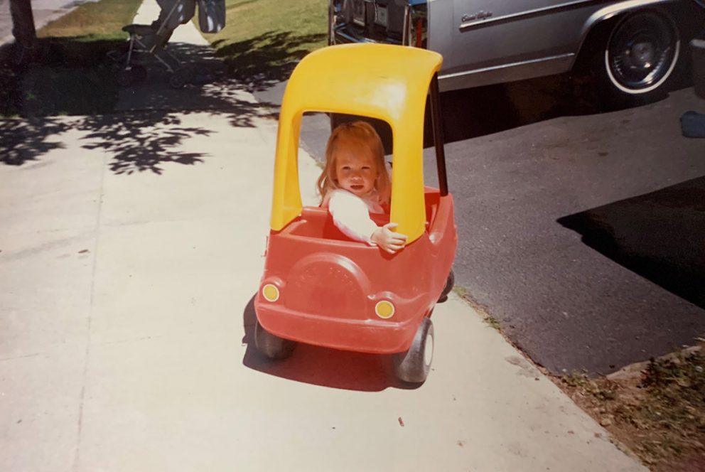 little girl in a toy car