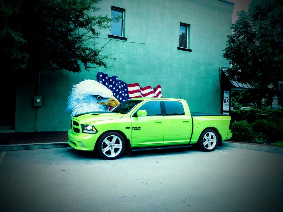 vehicle on display in front of bald eagle and American flag wall mural