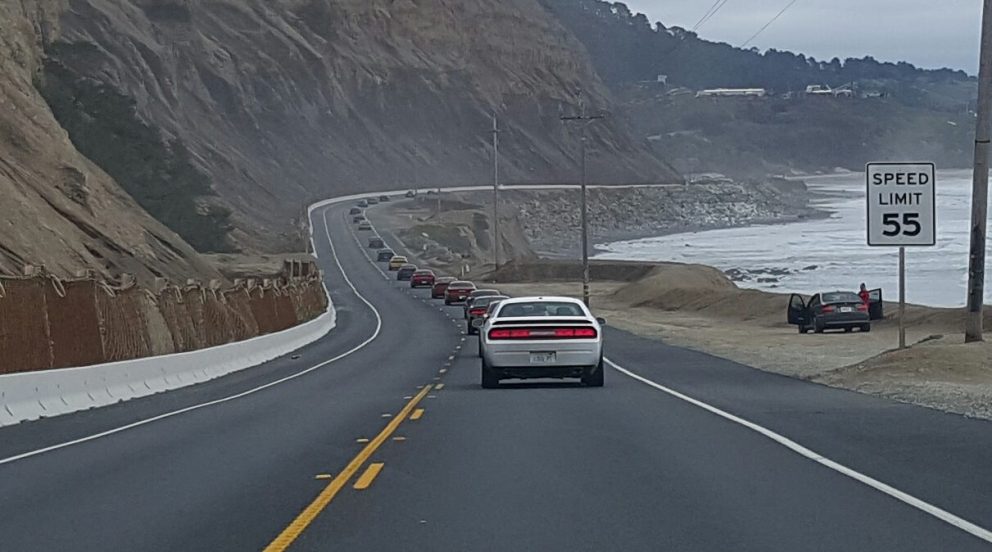 vehicles driving down the road in a line