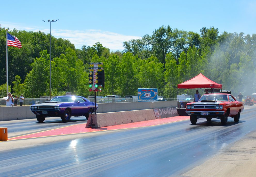 two vehicles racing on a drag strip
