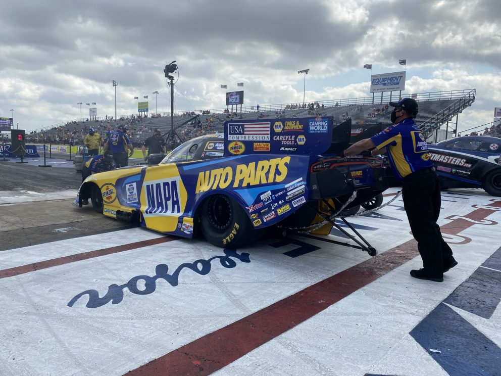 Ron Capps' team pushing his car to the start line
