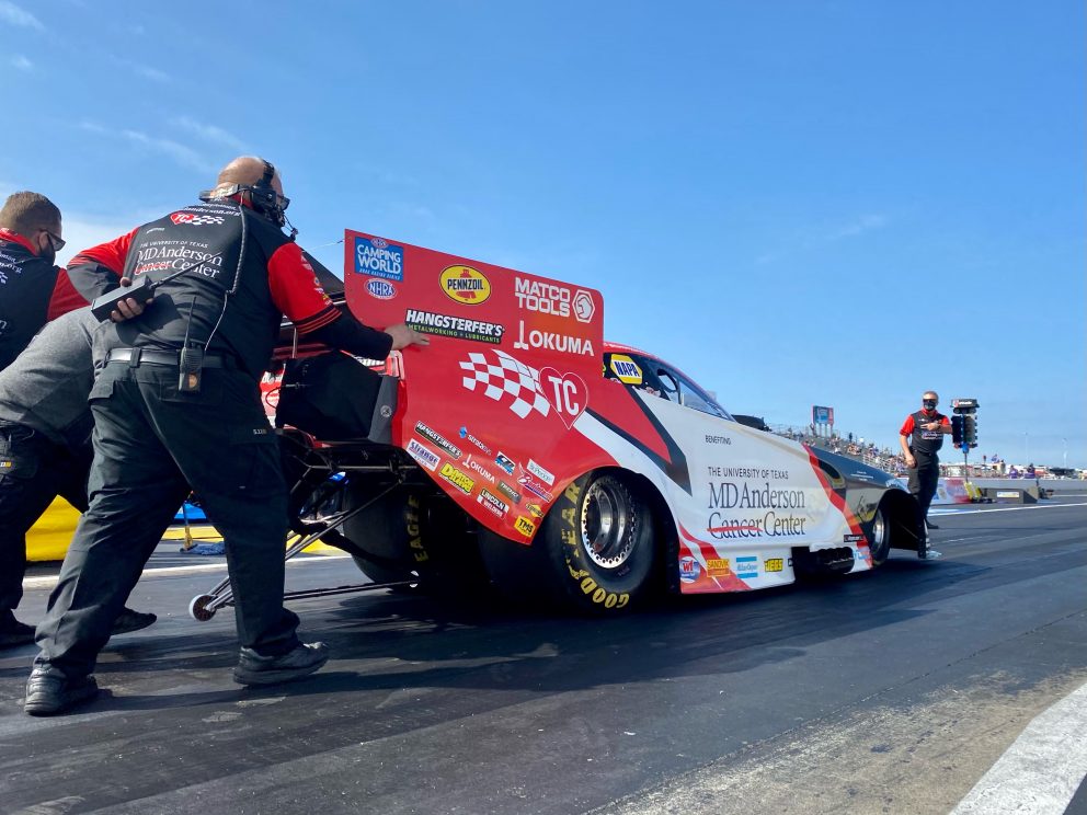 Tommy Johnson Jr's crew pushing his funny car to the start line