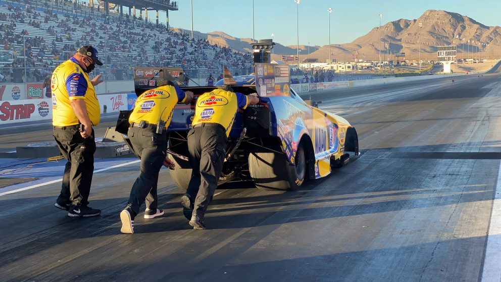 Ron Capps' team pushing his car to the start line