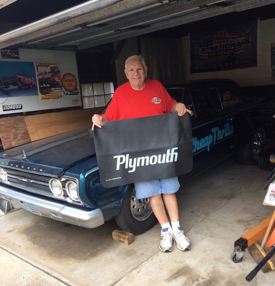 John holding up a Plymouth banner