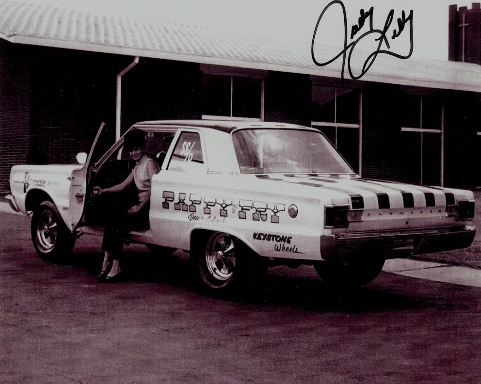 Judy Lilly sitting inside of her drag car