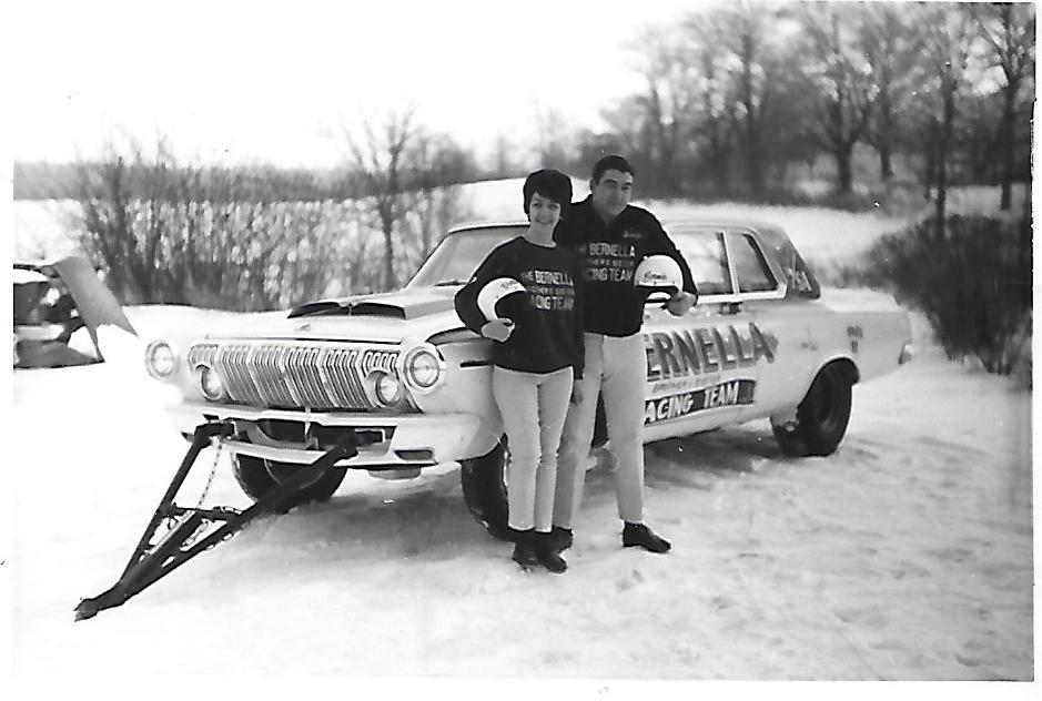 Della Woods and her brother standing next to their race car