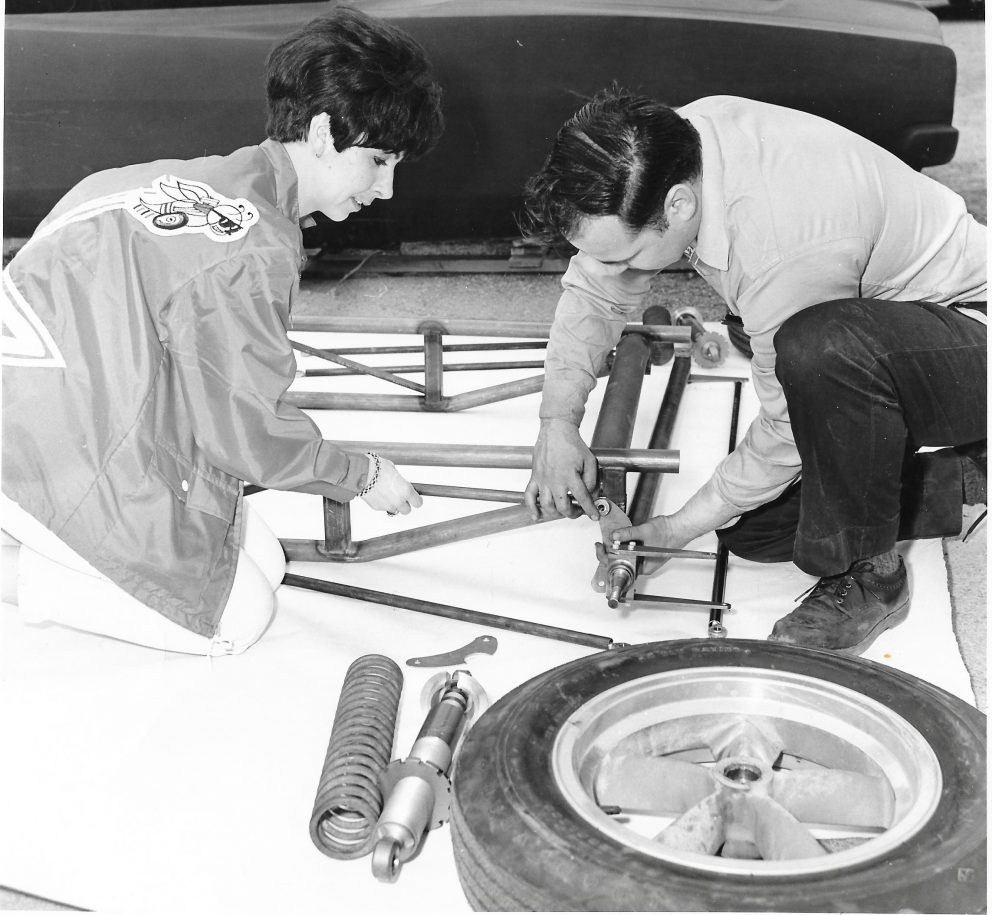 Della Woods working on her car with her brother