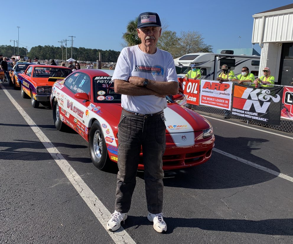 Mark Nowicki standing outside of his race car