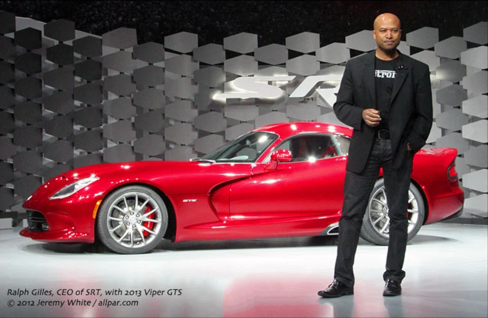 Ralph Gilles standing in front of the Viper wearing a Detroit shirt