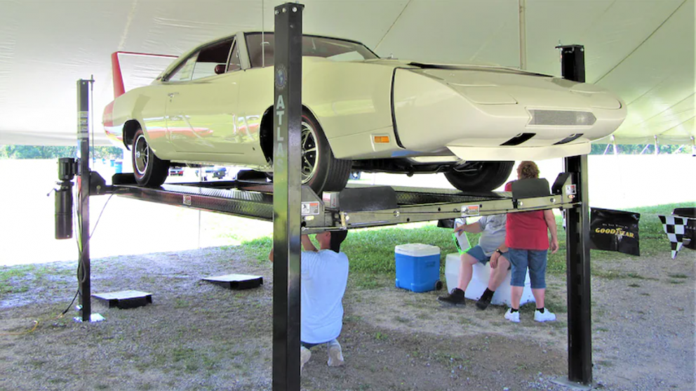 People working on a suspended 1969 Dodge Daytona