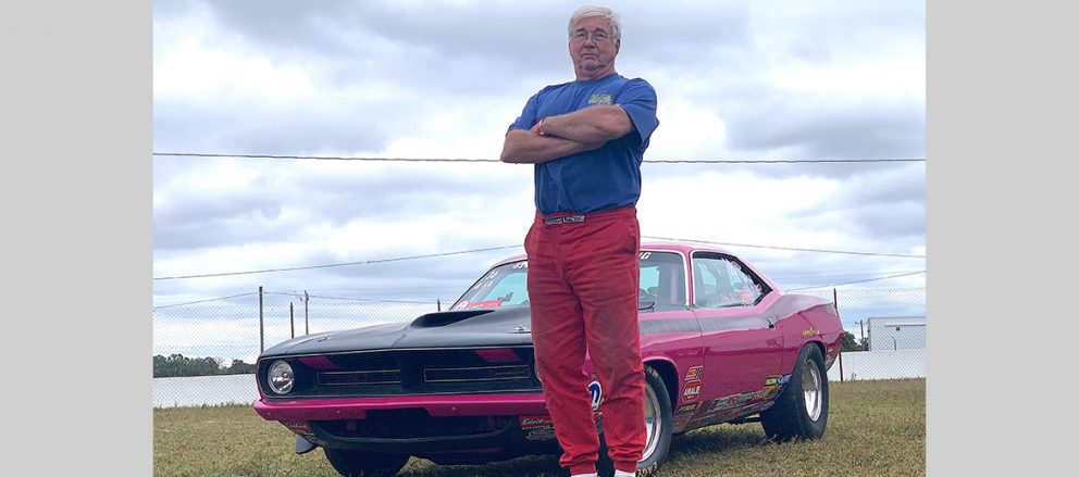 Larry Hill standing in front of his drag car
