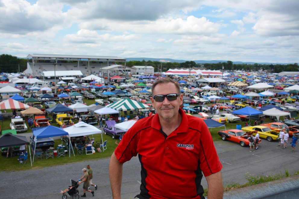 Man in front of a full lot of vehicles on display