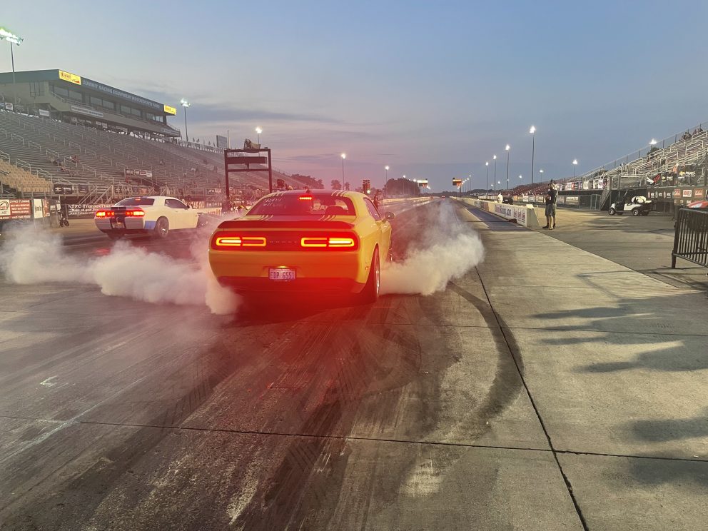 Two Challengers doing a burnout prior to drag racing