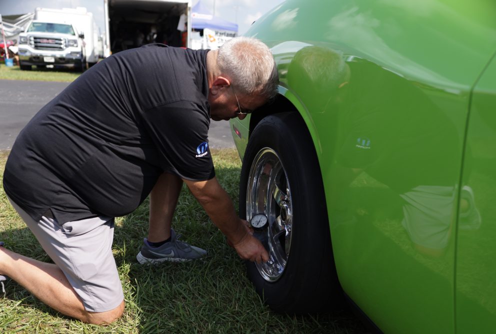 Man checking tire pressure before a drag race
