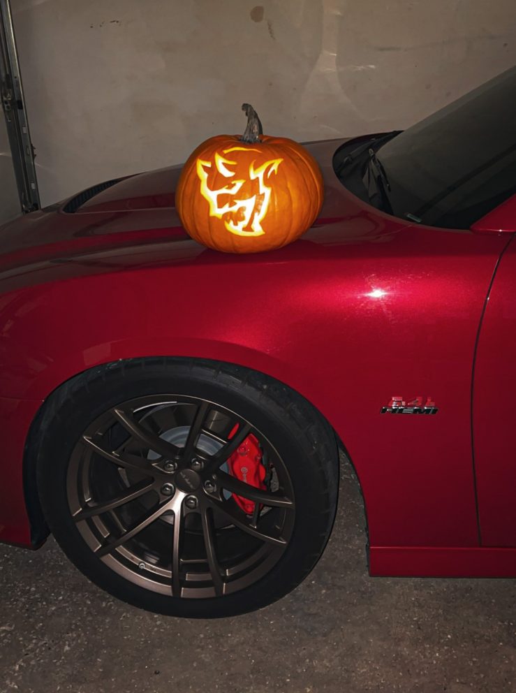 Demon pumpkin sitting on the hood of a Dodge vehicle