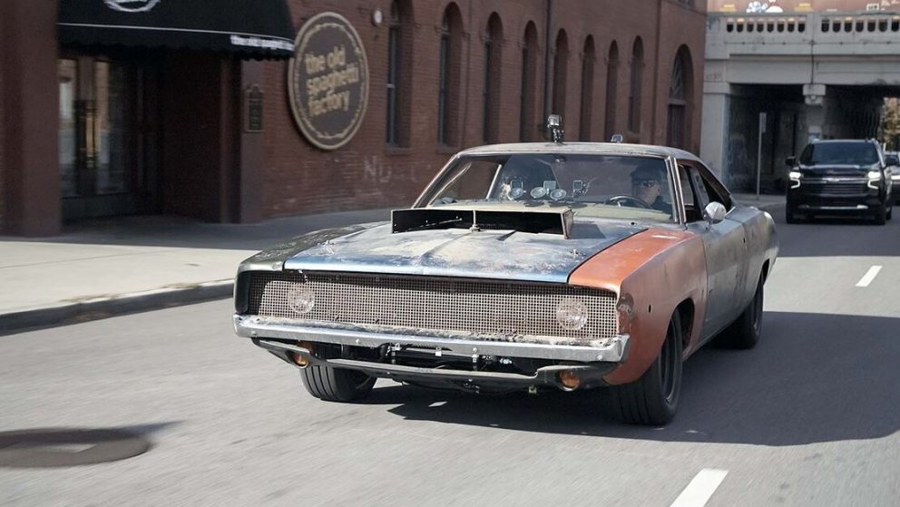 A vintage Dodge Charger driving down the road