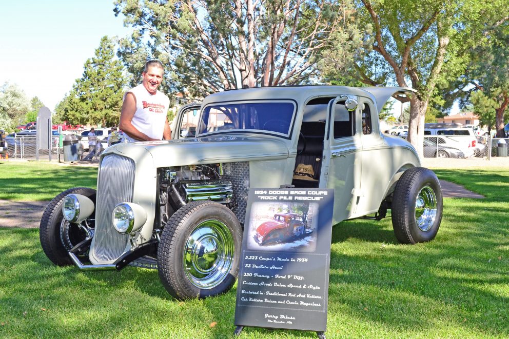 man standing next to vintage car