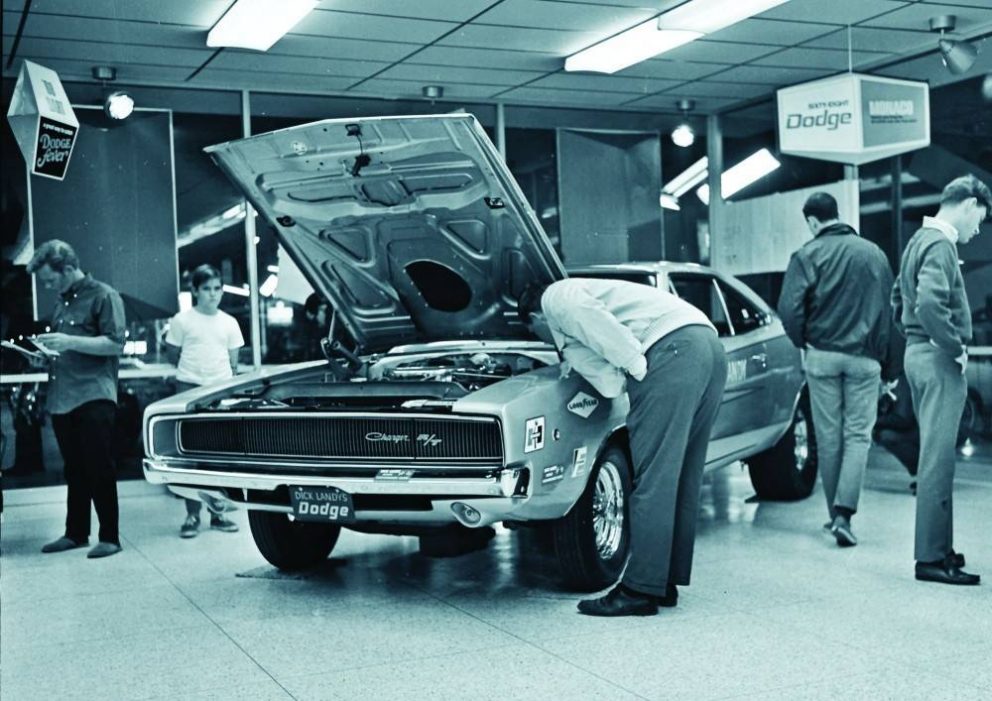 men looking at a car inside a dealership