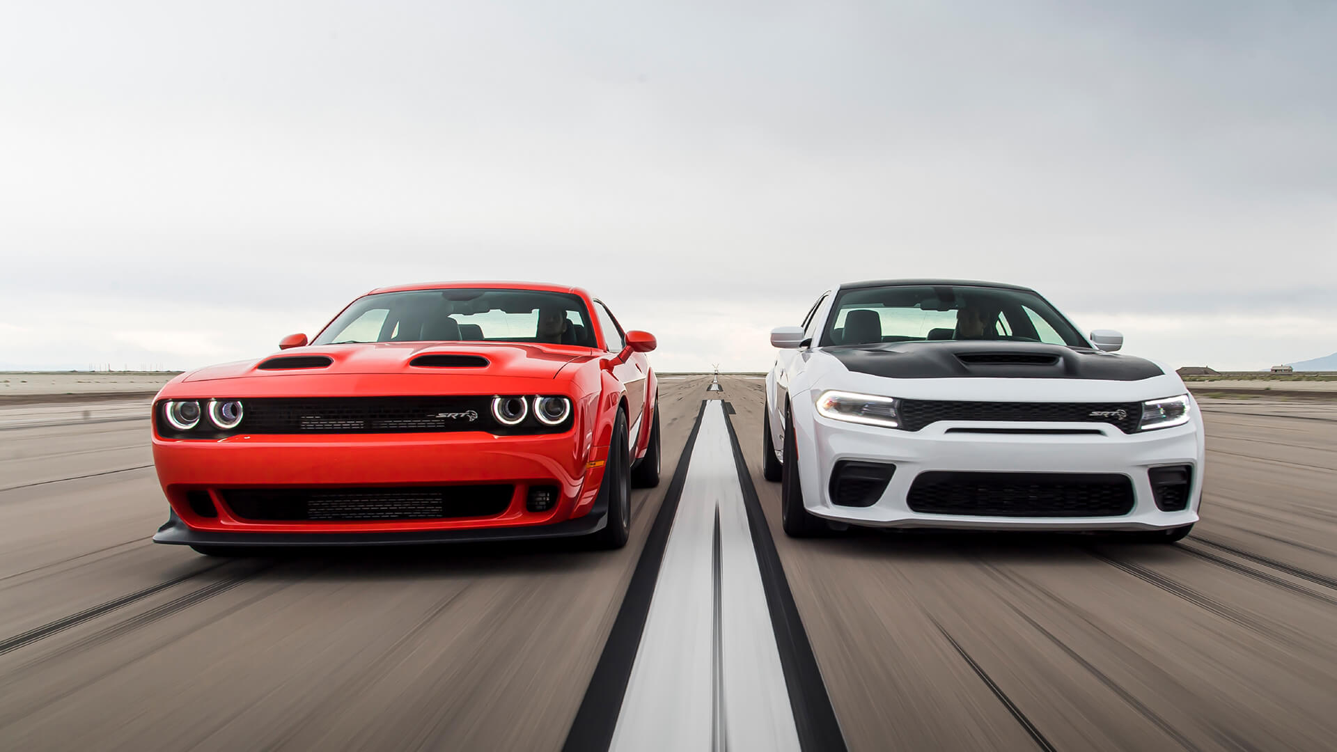 Sports cars speeding down a runway.