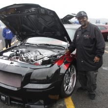 Man standing next to dodge vehicles