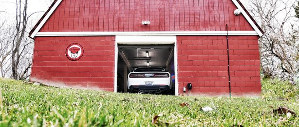 dodge demon pulling out of a barn