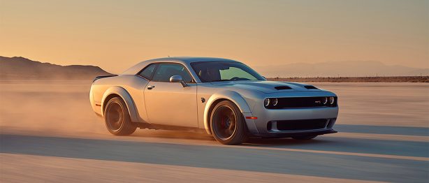 Man posing next to a dodge hellcat redeye