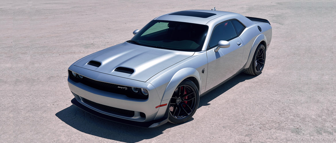 Man posing next to a dodge hellcat redeye