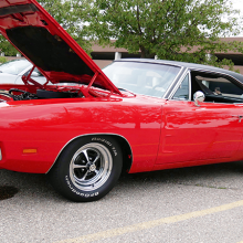 Red convertable dodge charger with its hood popped