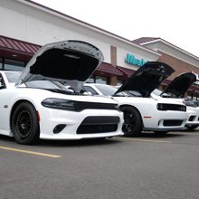 Three dodge vehicles lined up with their hoods popped