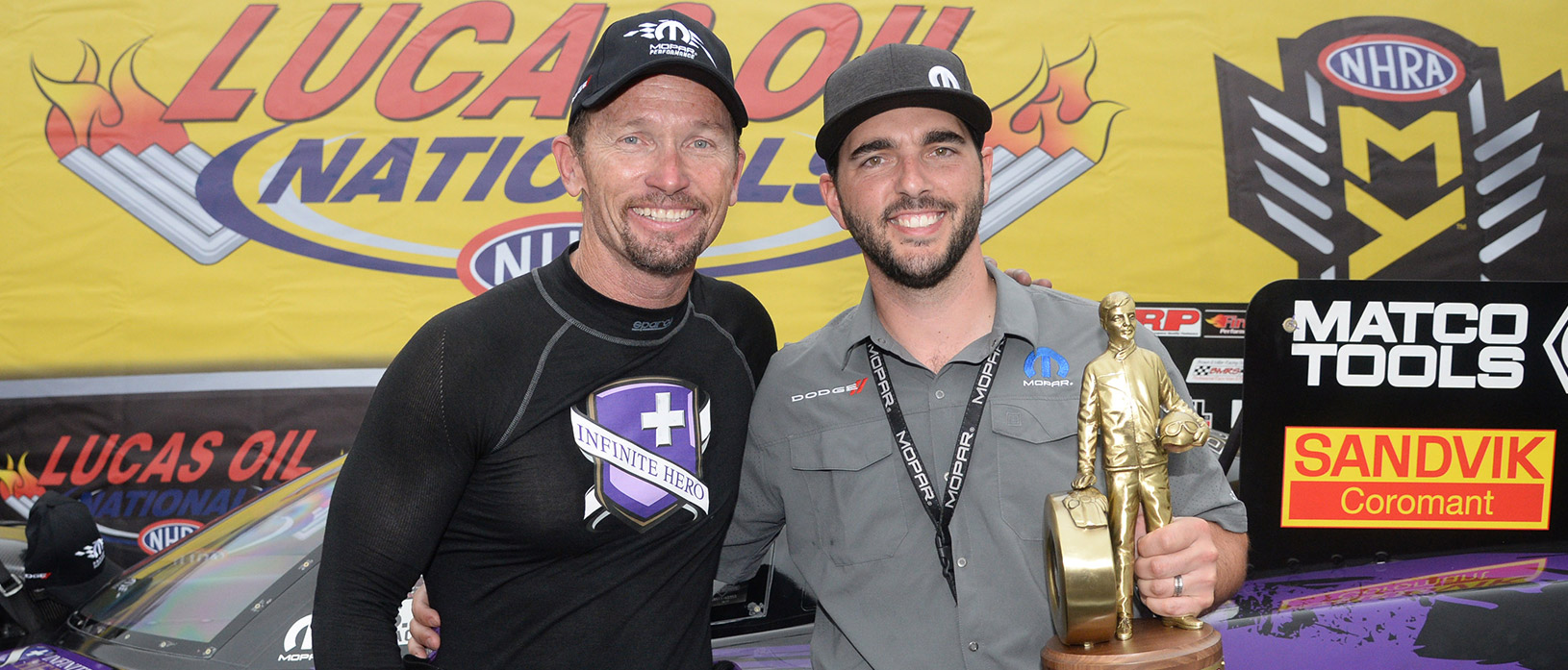 Man posing with racecar and friend after wining Lucas oil nationals