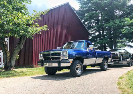 Blue raised truck by a barn